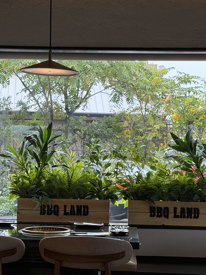 Window table framed by BBQ Land planters